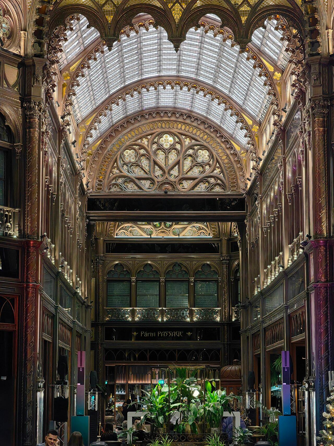 The covered arcade from inside, with a vault of glass and iron above the shopping walkway