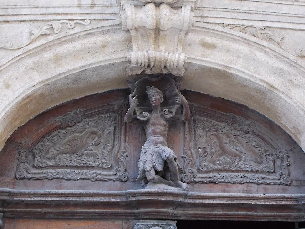 Wood carving above a church door, with a figure among tendrils and birds