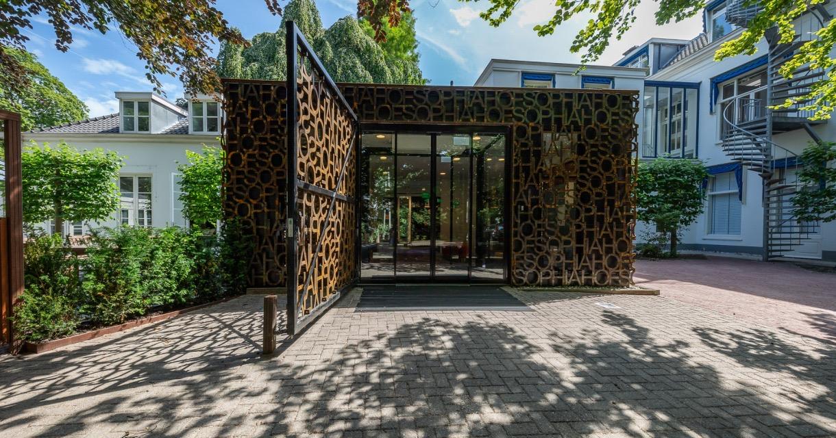 The entrance pavilion of Museum Sophiahof in The Hague, clad in rusted steel letters spelling the museum's name